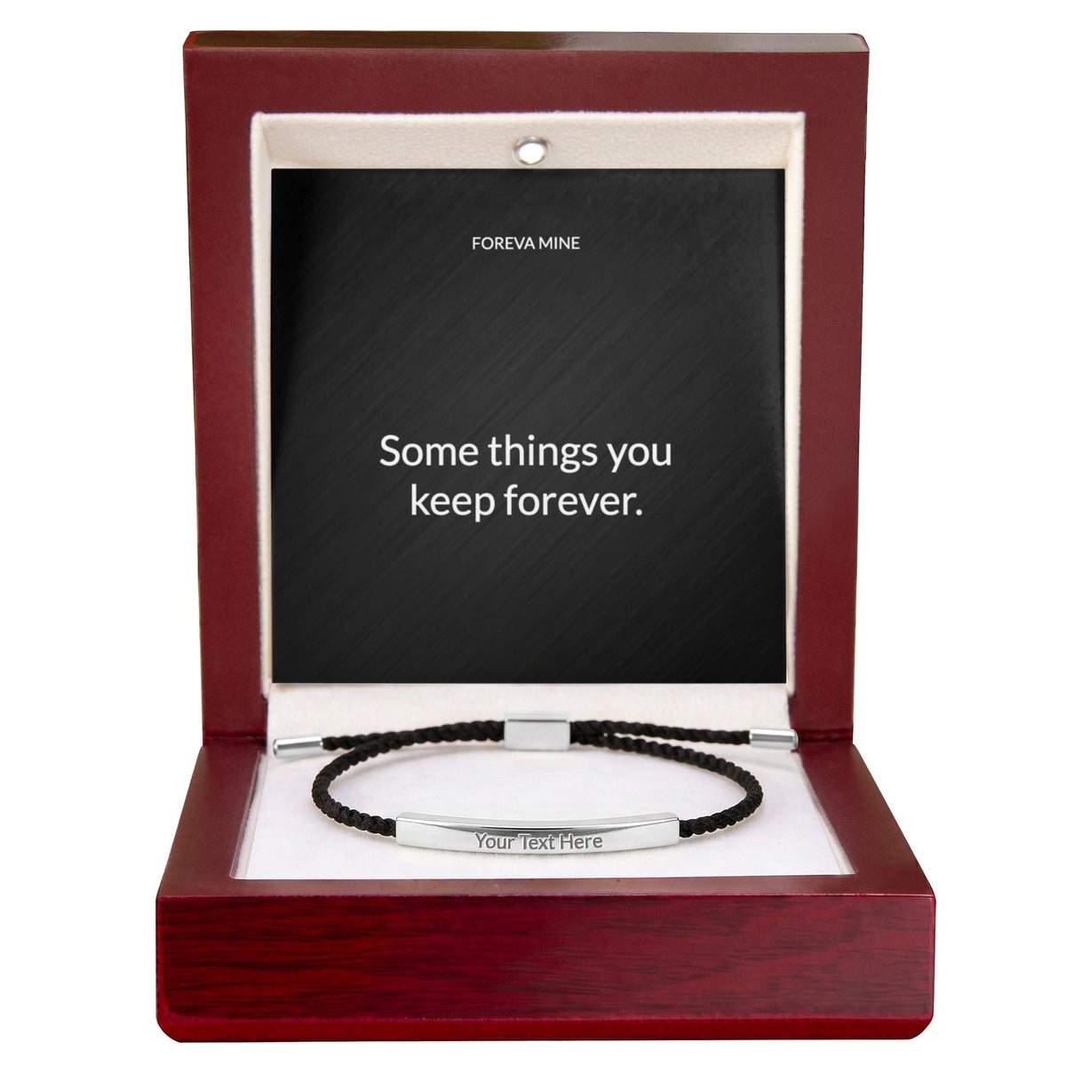 The luxury gift box: a mahogany-finish wooden box with a cream lining and a small light in the lid, holding the same silver engraved cord bracelet and message card